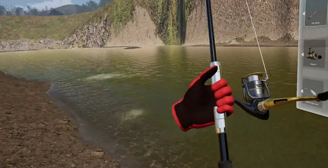 Gloved hands holding a rod and reel at the river's edge in the game
