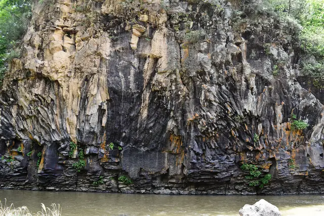Columnar basalt cliffs above the water on a branch of the Hantan River