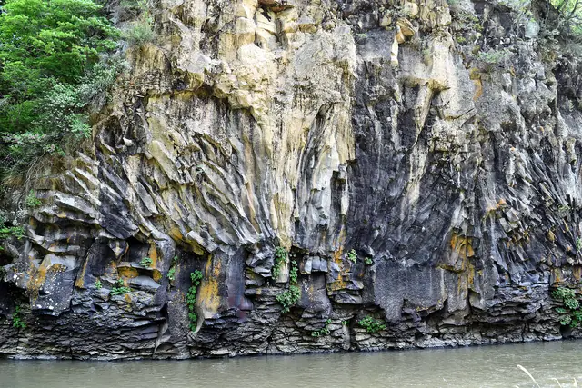Columnar basalt cliffs above the water on a branch of the Hantan River